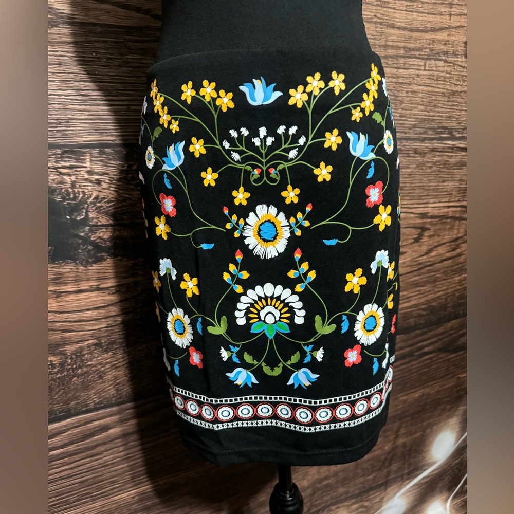 SHEIN Curve 1x black skirt with floral design on the front.